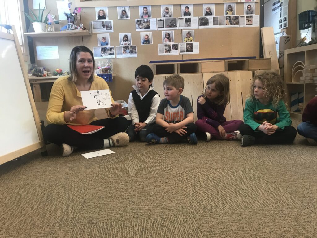 teacher showing a drawing to her students