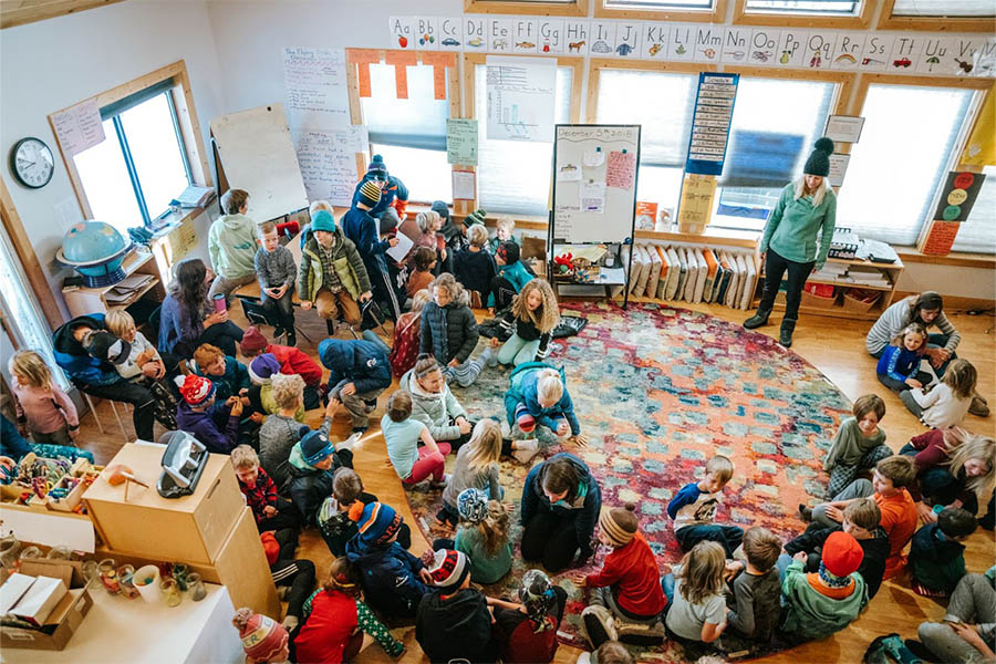A wide angle from above showing lots of students sitting in a classroom at Mountain Academy.